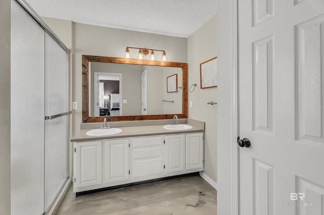 23214 Rochelle Loop, Robertsdale, AL 36567 - bathroom featuring a textured ceiling, a shower stall, double vanity, ensuite bathroom, and finished concrete floors
