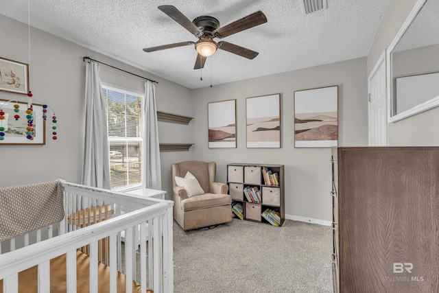 23214 Rochelle Loop, Robertsdale, AL 36567 - carpeted bedroom with a crib, a textured ceiling, and a ceiling fan