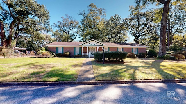 view of front of home featuring a porch, a front lawn, and brick siding