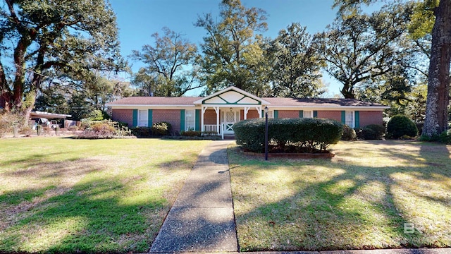 ranch-style home featuring covered porch, brick siding, and a front lawn