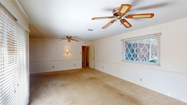 empty room with ceiling fan, carpet floors, and visible vents