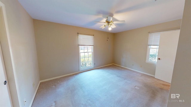 spare room with carpet flooring, a ceiling fan, and baseboards