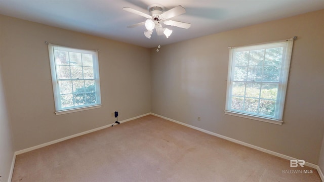 unfurnished room with baseboards, ceiling fan, and light colored carpet