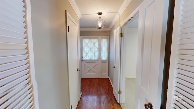 entryway featuring baseboards, ornamental molding, and wood finished floors