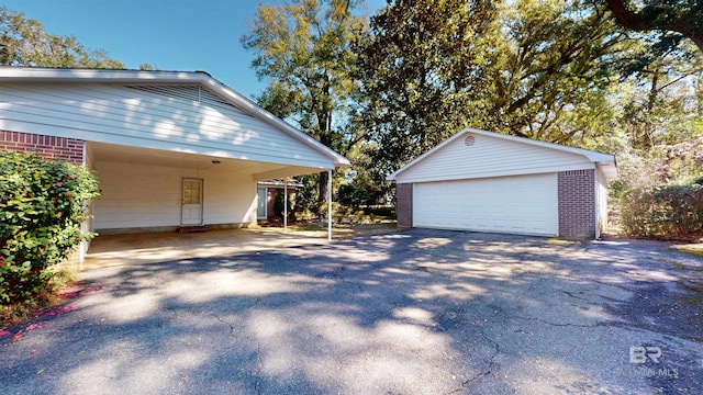 exterior space with a garage, brick siding, and an outdoor structure