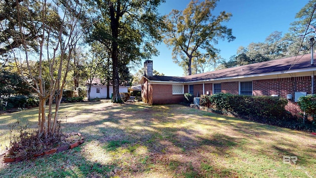 exterior space featuring central AC, brick siding, a front lawn, and a chimney