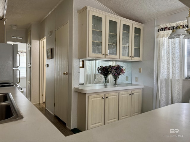 kitchen with a sink, light countertops, a textured ceiling, and white appliances