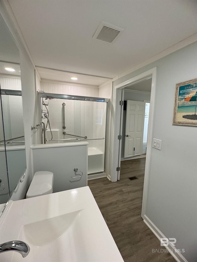 full bath featuring visible vents, an enclosed shower, wood finished floors, baseboards, and recessed lighting