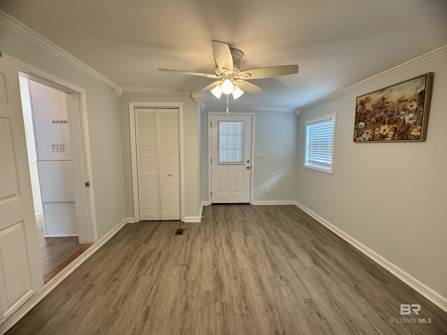 entryway featuring crown molding, ceiling fan, and wood finished floors