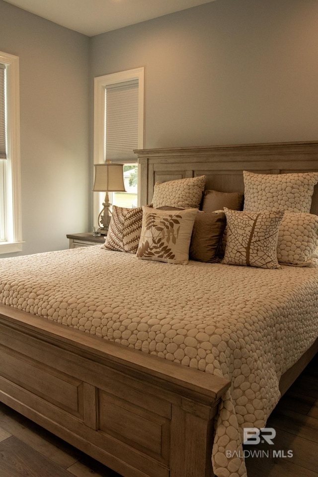 unfurnished bedroom featuring dark wood-type flooring and multiple windows