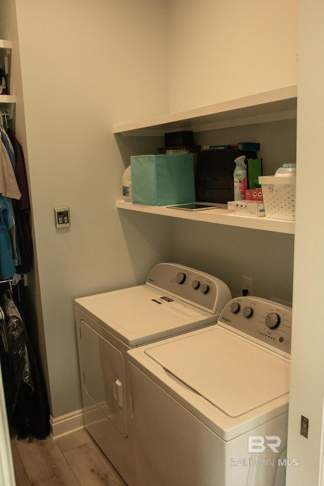 laundry area featuring washer and clothes dryer and wood-type flooring