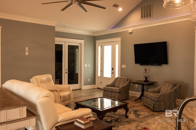 living room featuring hardwood / wood-style flooring, french doors, ceiling fan, crown molding, and lofted ceiling