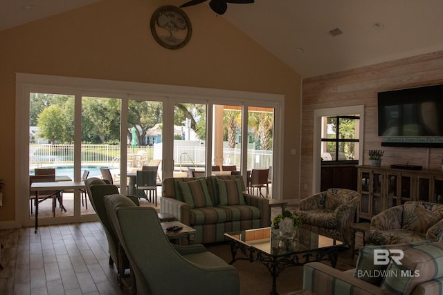 living room featuring ceiling fan, a wealth of natural light, high vaulted ceiling, and wood-type flooring