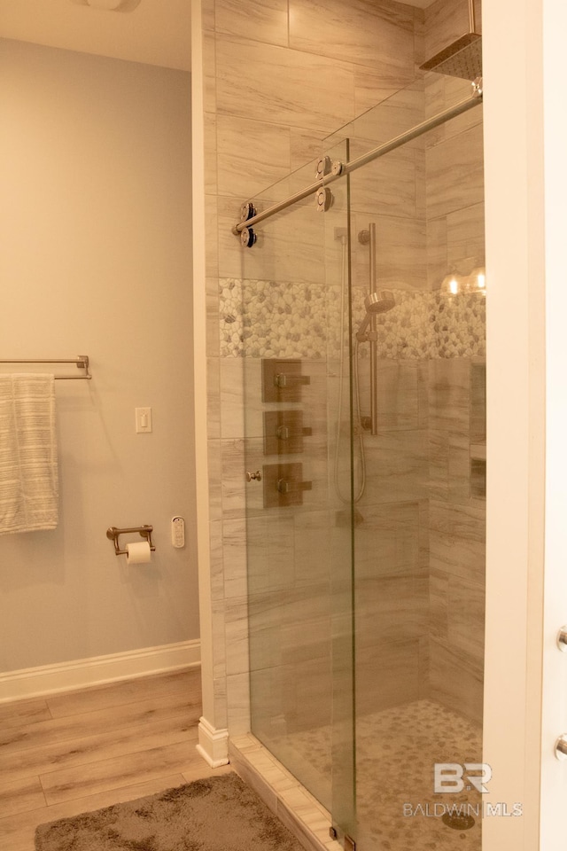 bathroom with hardwood / wood-style flooring and walk in shower