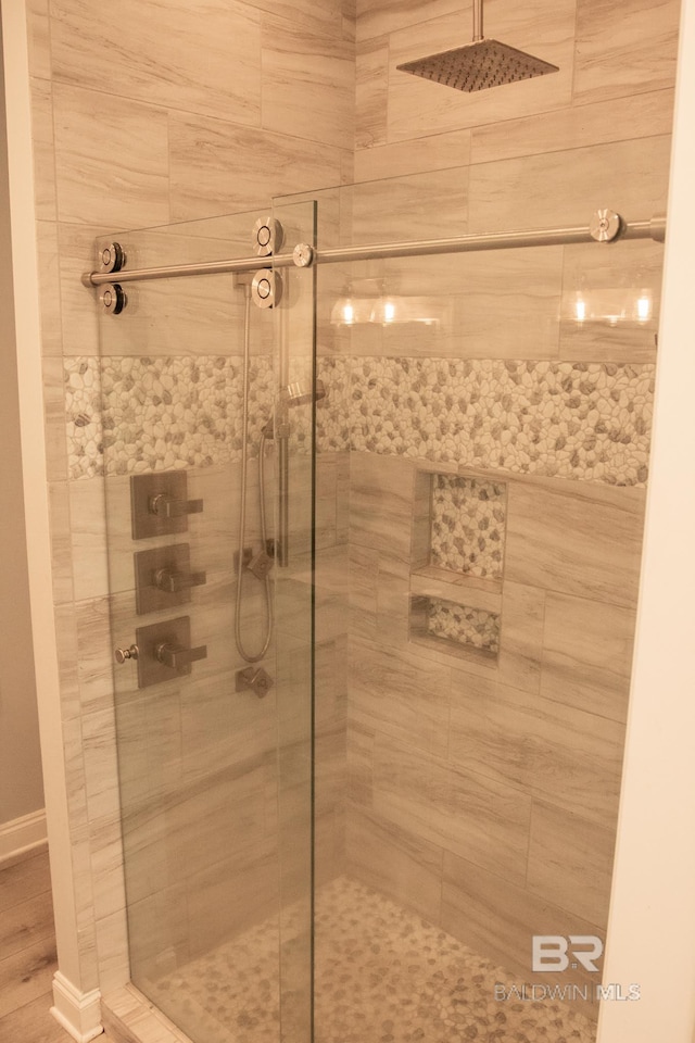 bathroom with hardwood / wood-style floors and a tile shower