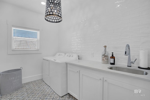 laundry area featuring cabinet space, independent washer and dryer, baseboards, and a sink