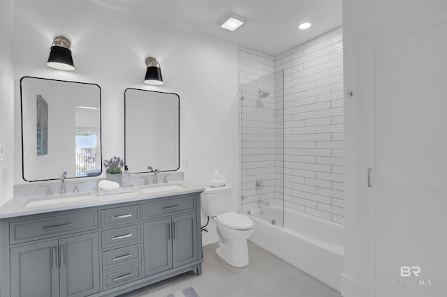 bathroom featuring double vanity, shower / bath combination, toilet, and a sink