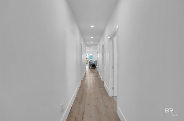 hall with recessed lighting, light wood-style floors, and baseboards