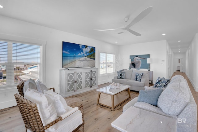 living room featuring recessed lighting, baseboards, a ceiling fan, and light wood finished floors