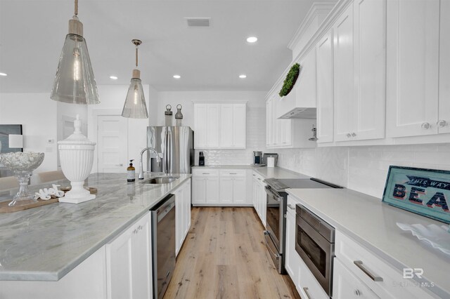 kitchen featuring visible vents, white cabinets, stainless steel appliances, and a sink