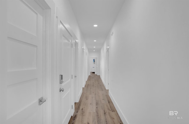 hall featuring recessed lighting, light wood-type flooring, and baseboards