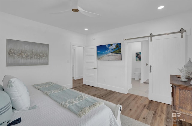 bedroom with baseboards, a barn door, recessed lighting, wood finished floors, and a ceiling fan