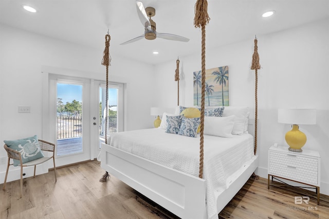 bedroom with recessed lighting, baseboards, wood finished floors, and access to outside