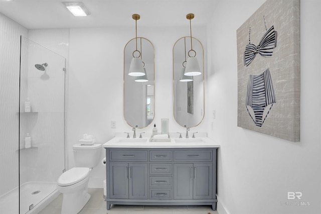 bathroom with a shower stall, toilet, double vanity, and a sink