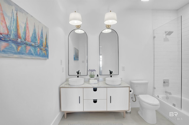 bathroom with a sink, toilet, double vanity, and tile patterned floors