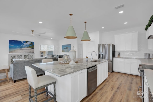 kitchen featuring light wood finished floors, visible vents, white cabinetry, and stainless steel appliances