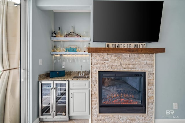 bar with wet bar, beverage cooler, and a sink