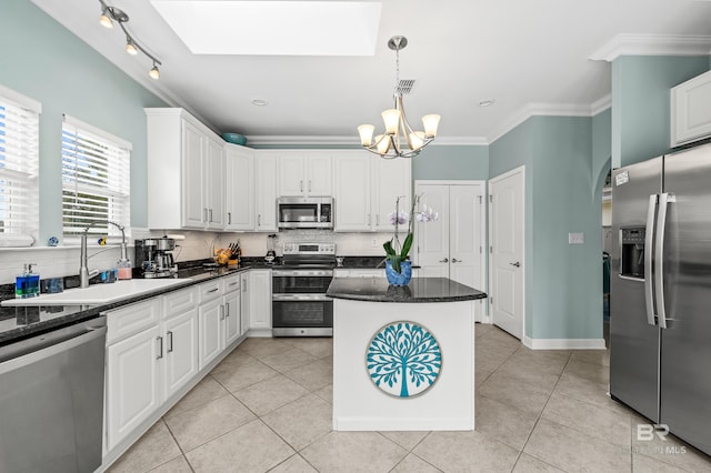 kitchen featuring light tile patterned floors, a sink, appliances with stainless steel finishes, decorative backsplash, and crown molding