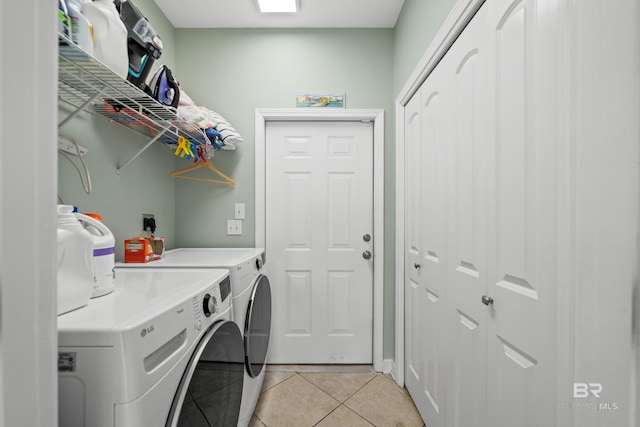 laundry room featuring laundry area, washer and clothes dryer, and light tile patterned floors