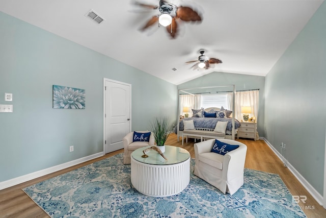 bedroom with visible vents, baseboards, ceiling fan, wood finished floors, and vaulted ceiling