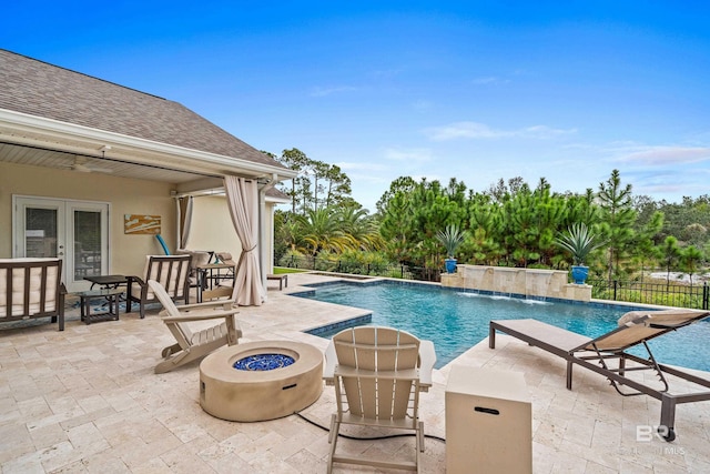 view of pool featuring a fire pit, a fenced in pool, fence, french doors, and a patio area