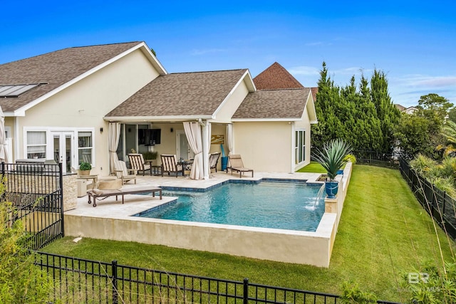 back of property with stucco siding, a shingled roof, a lawn, a patio area, and a fenced backyard