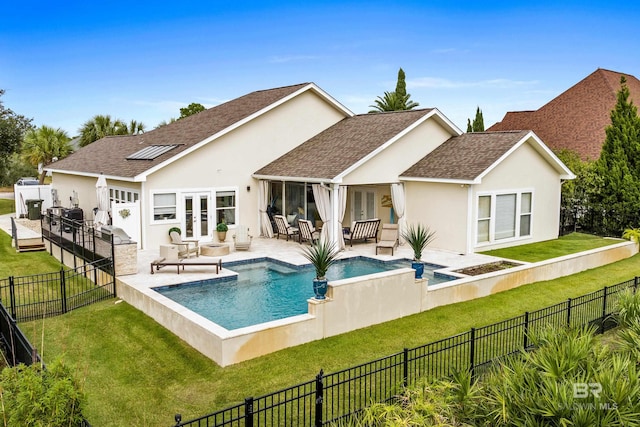 rear view of house with a fenced backyard, a shingled roof, a yard, french doors, and stucco siding