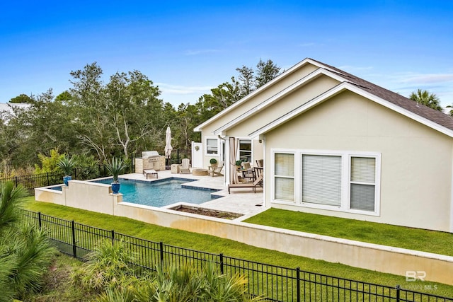 view of pool with a yard, exterior kitchen, a fenced backyard, and a fenced in pool