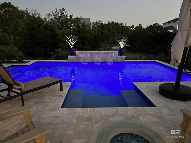 outdoor pool with a patio and a hot tub