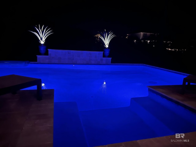 pool at night with an outdoor pool