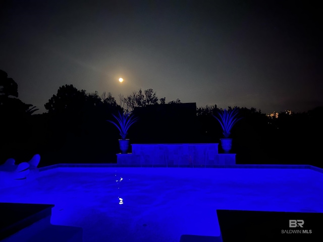 view of pool at night