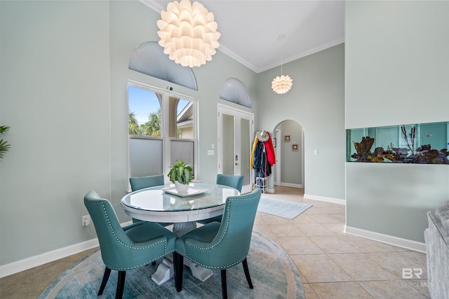 dining room with baseboards, arched walkways, ornamental molding, an inviting chandelier, and light tile patterned flooring