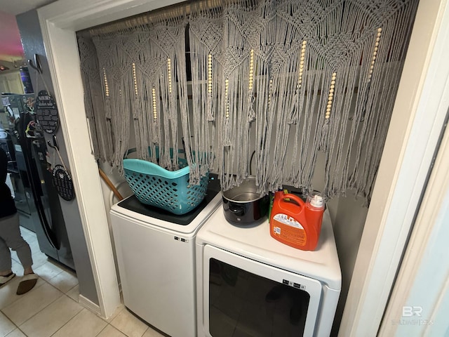 clothes washing area with laundry area, tile patterned floors, and washing machine and clothes dryer