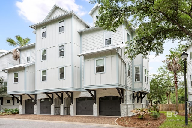4672 Grander Ct Unit 15B, Orange Beach, AL 36561 - back of property with board and batten siding, fence, a garage, and decorative driveway