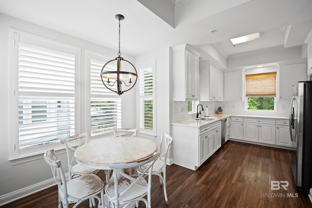 4672 Grander Ct Unit 15B, Orange Beach, AL 36561 - kitchen with stainless steel appliances, a sink, dark wood-style floors, a chandelier, and white cabinets