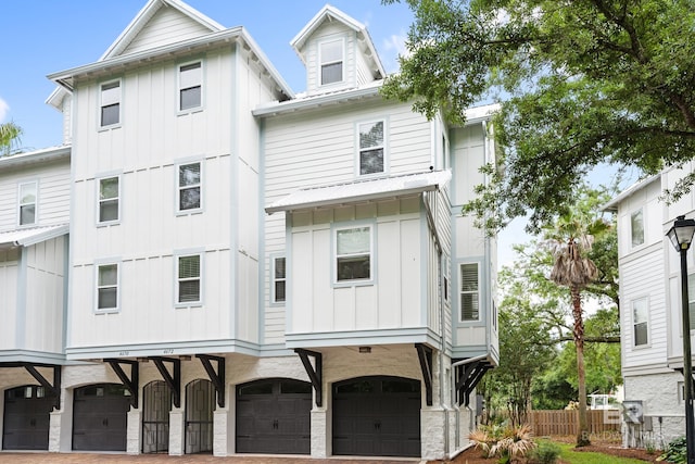 4672 Grander Ct Unit 15B, Orange Beach, AL 36561 - back of property with board and batten siding, a garage, fence, and driveway