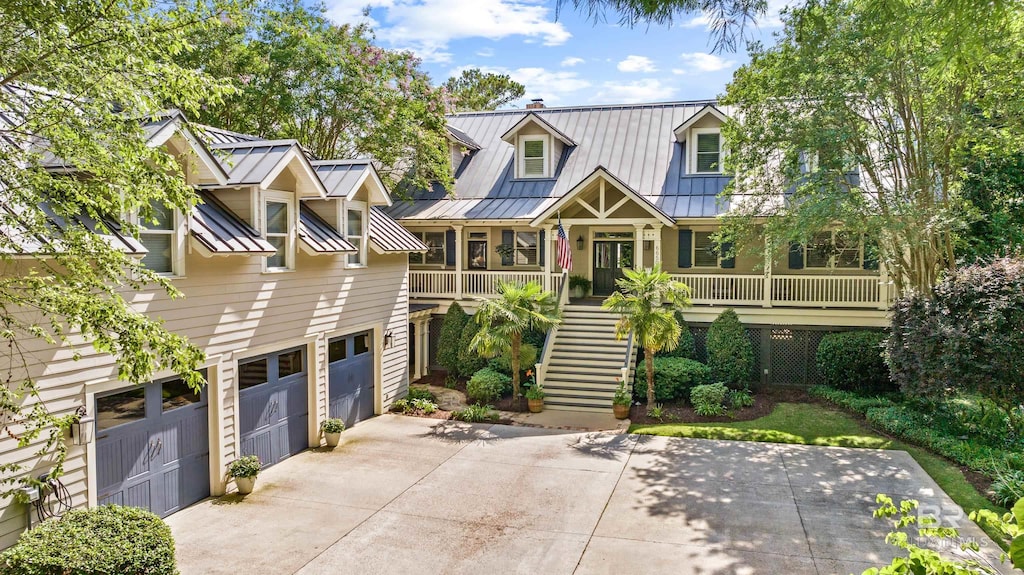 6650 Cedar Brook Dr, Fairhope, AL 36532 - view of front of property featuring concrete driveway, a standing seam roof, a porch, stairway, and metal roof