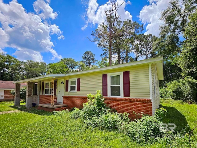 ranch-style house featuring brick siding and a front yard