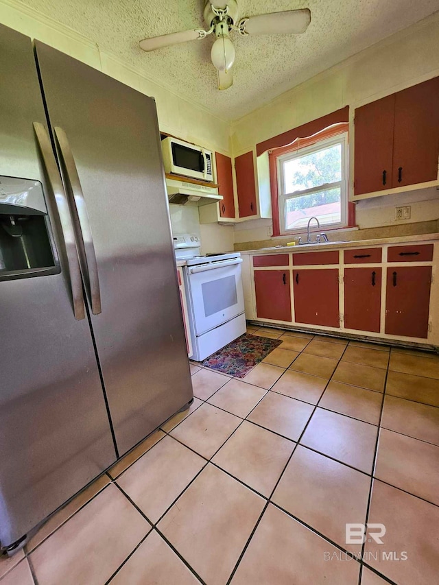 kitchen with light tile patterned floors, white appliances, a textured ceiling, and a ceiling fan