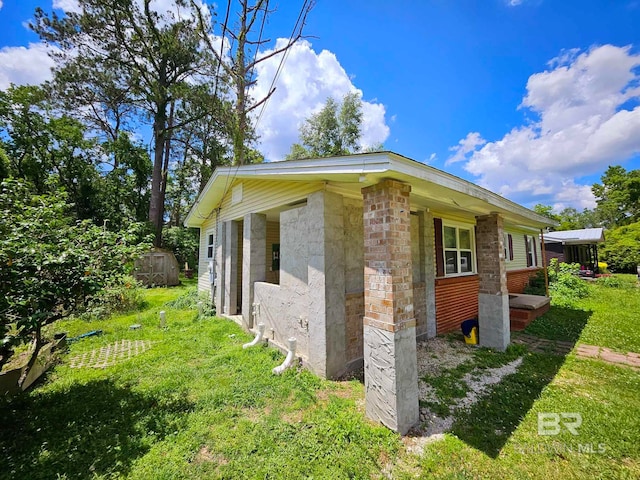 view of home's exterior with a shed, an outdoor structure, and a yard